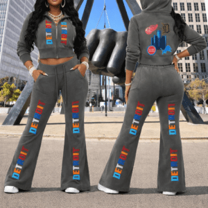Model wearing a grey vintage-washed cropped fleece hoodie and matching flared sweatpants with colorful “Detroit” text, shown front and back in an urban downtown setting featuring the Joe Louis Fist.