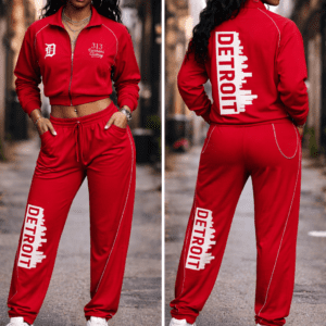 Front and back view of a 313 Emblems black zip-up tracksuit. The jacket features a cropped fit with Detroit skyline and sports team patches on the back. The matching flare joggers feature "DETROIT" in colorful block letters down the legs.